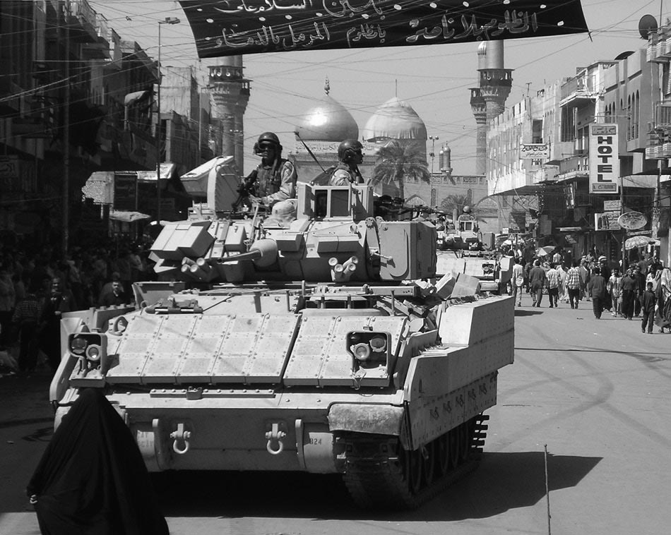 With local national police and army units, a 1-5 CAV Bradley secures a traffic control point near the Imam Kadhum Mosque, March 2004. 